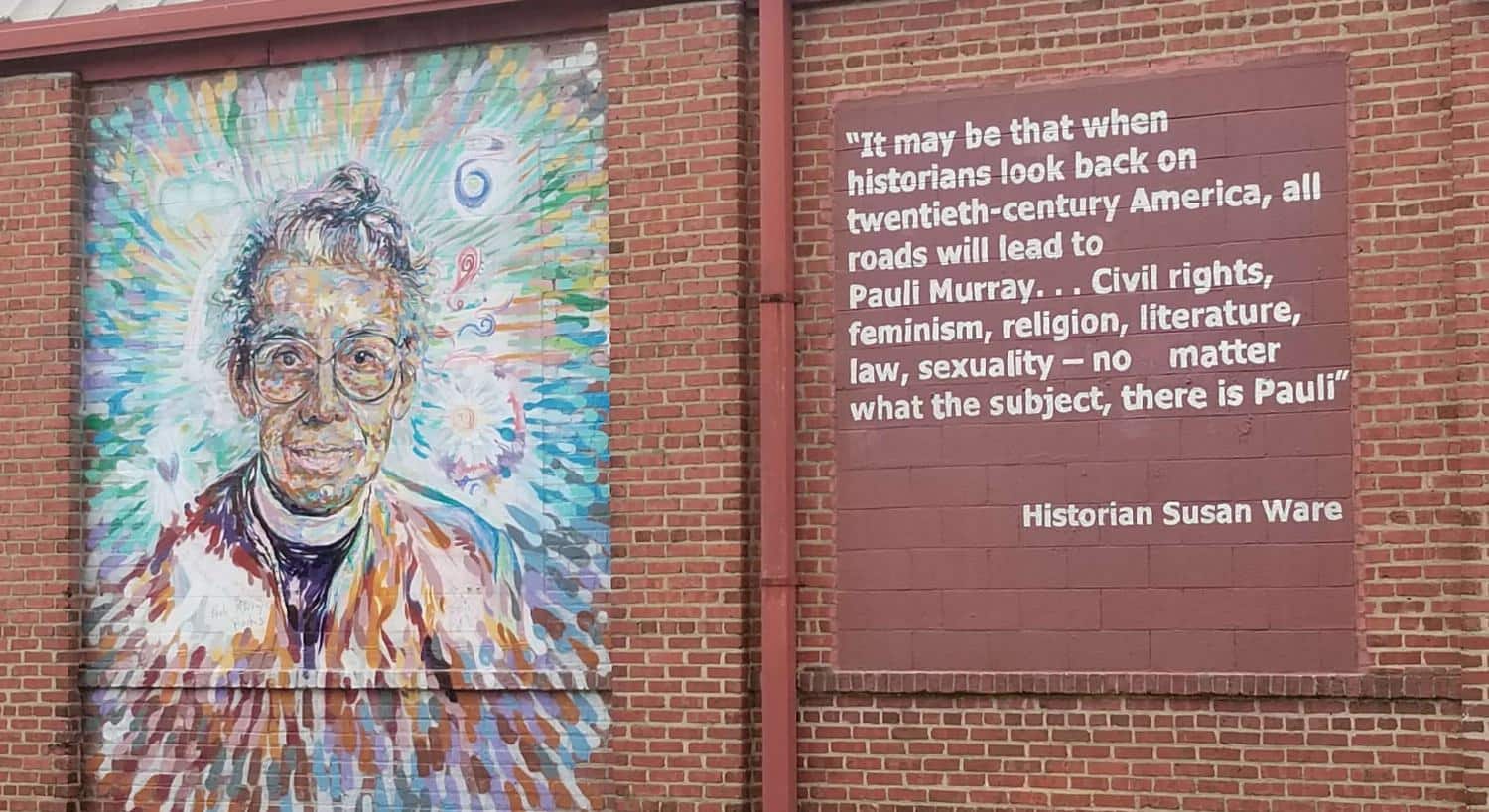 Red brick wall with painting of a woman named Pauli Murray and a historical quote