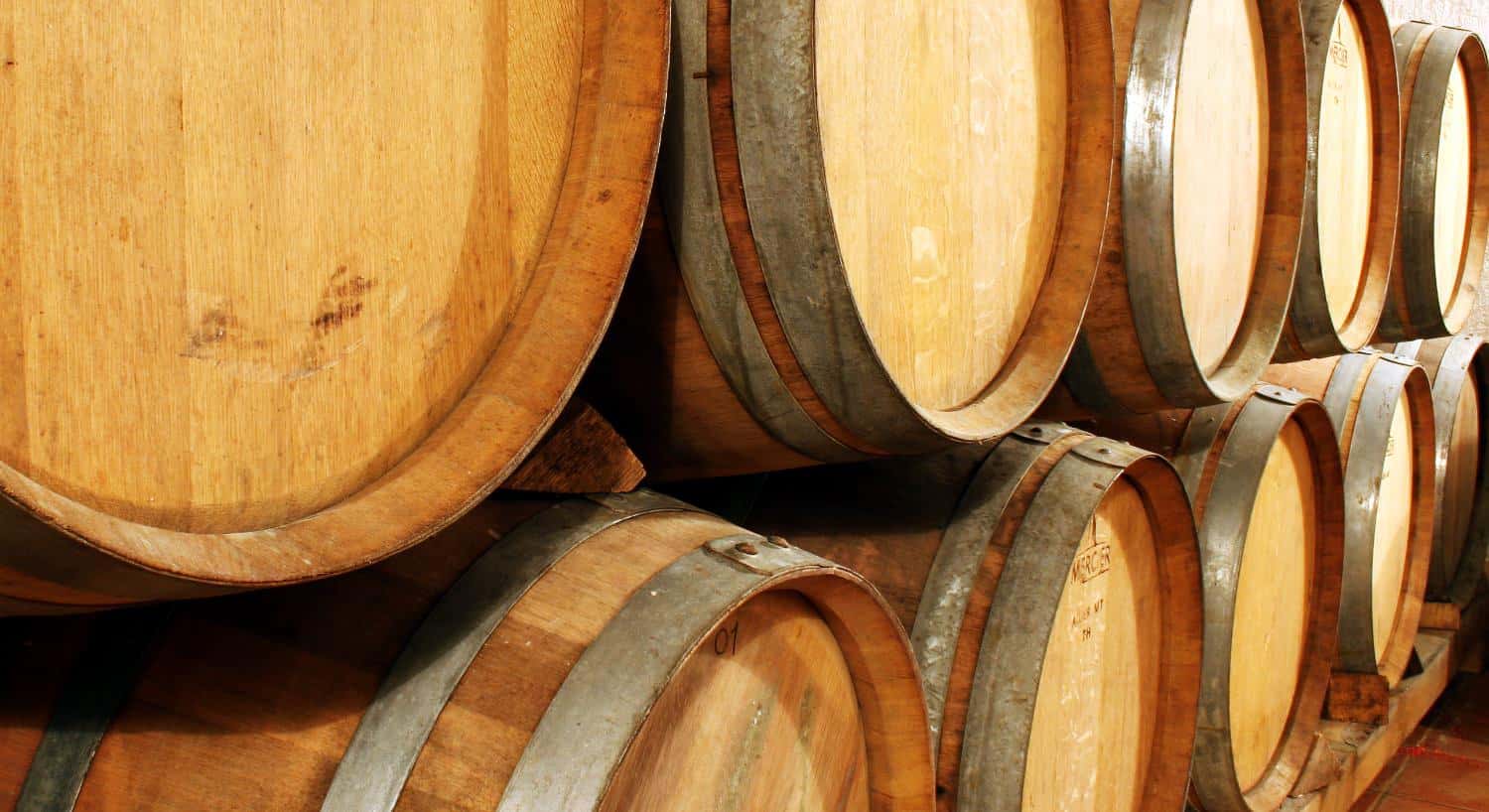Close up view of stacked oak barrels aging spirits