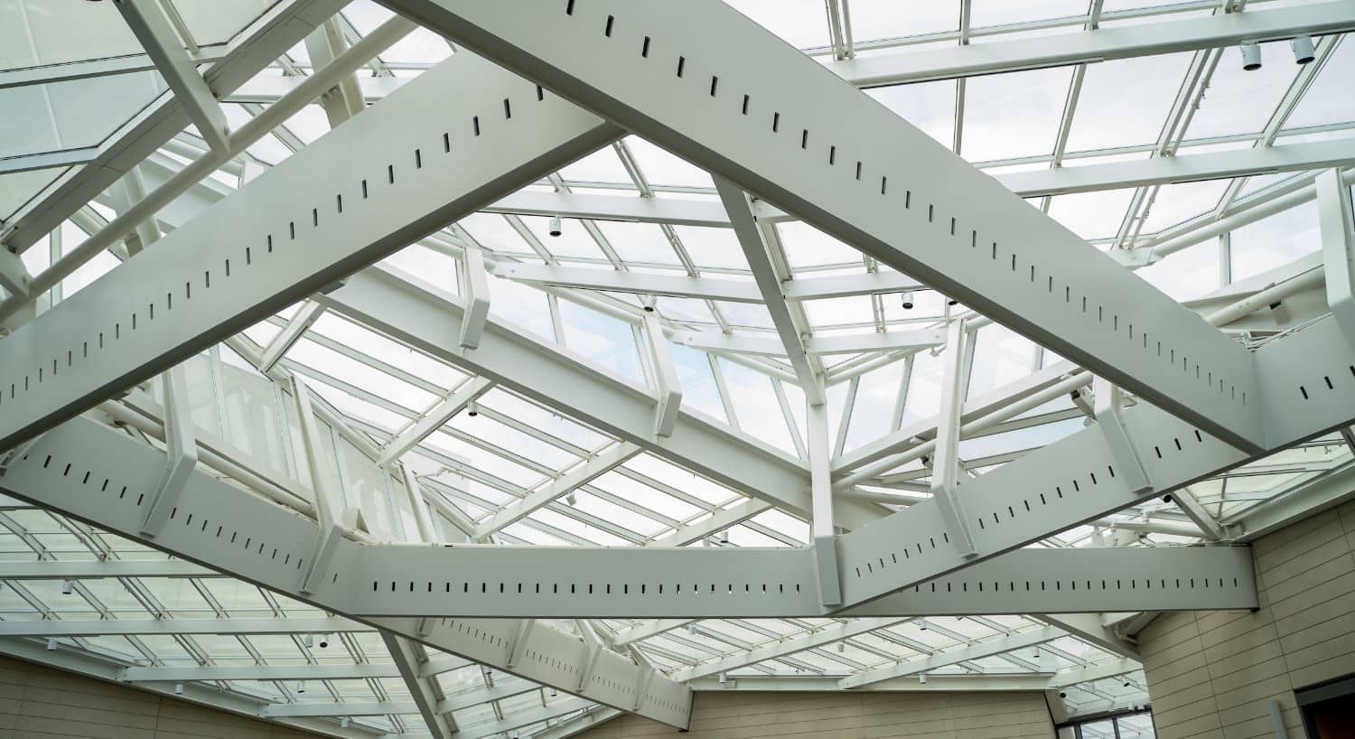 Large white metal supports and windows artistically arranged as roof and ceiling of a museum