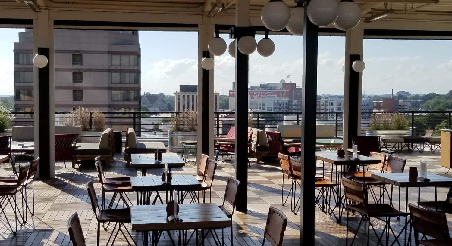 Large room in a restaurant with wooden tables and downtown view