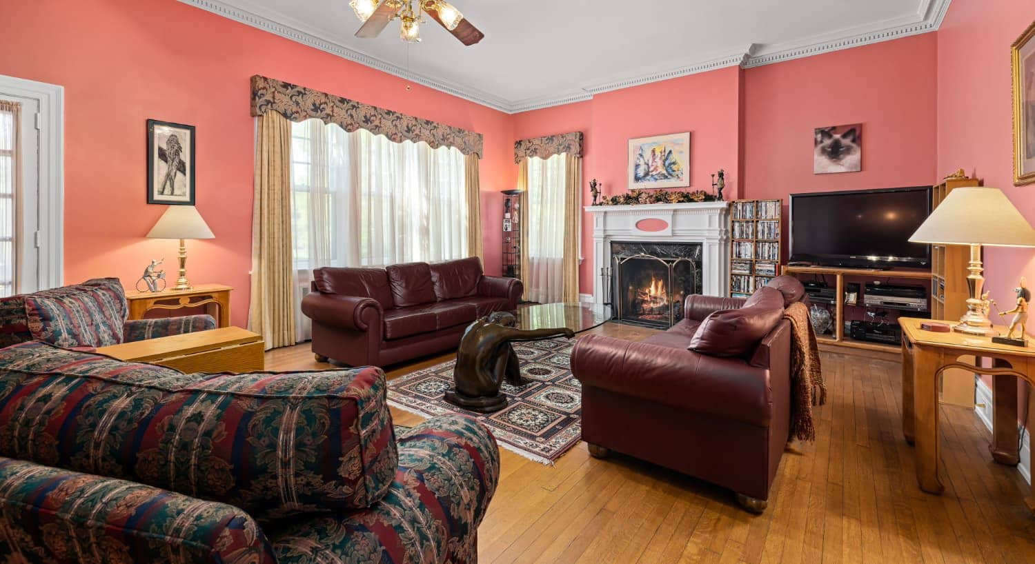 Living room with coral walls and brown leather sofas