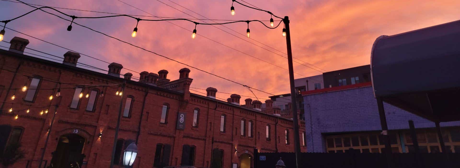 Downtown brick buildings with setting sun and bistro lights
