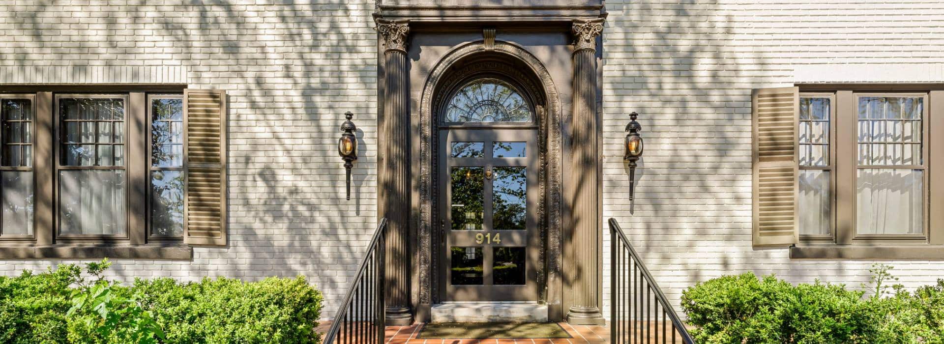Front entrance of Morehead Manor with white brick and brown shutters