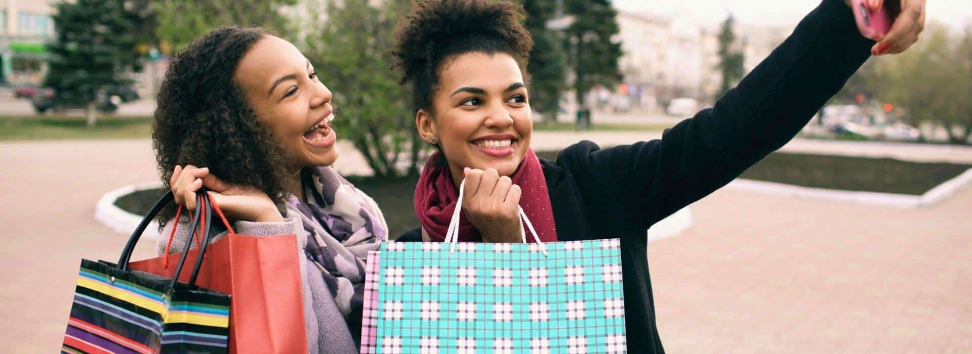 Friends taking a selfie with shopping bags after a day of shopping in Durham, NC.