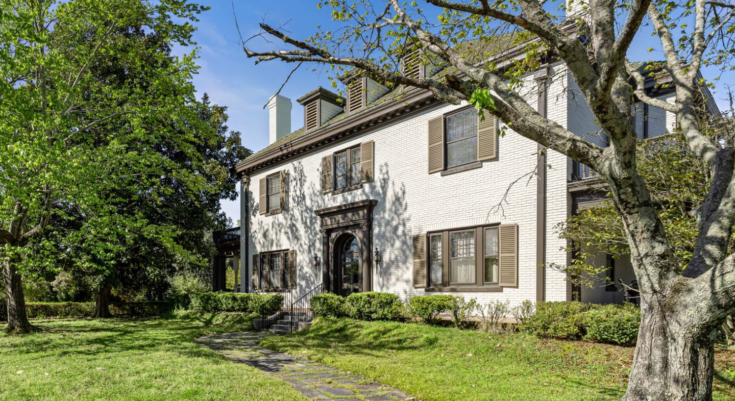 Exterior view of Morehead Manor with white brick and brown shutters
